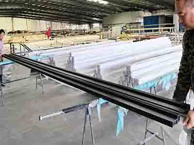 Quality control team inspecting finished FRP profiles at the factory